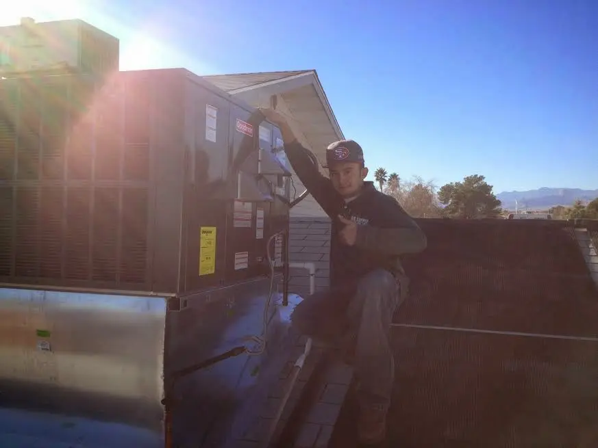 HVAC technician performing HVAC Inspection on a rooftop unit in Kalkaska